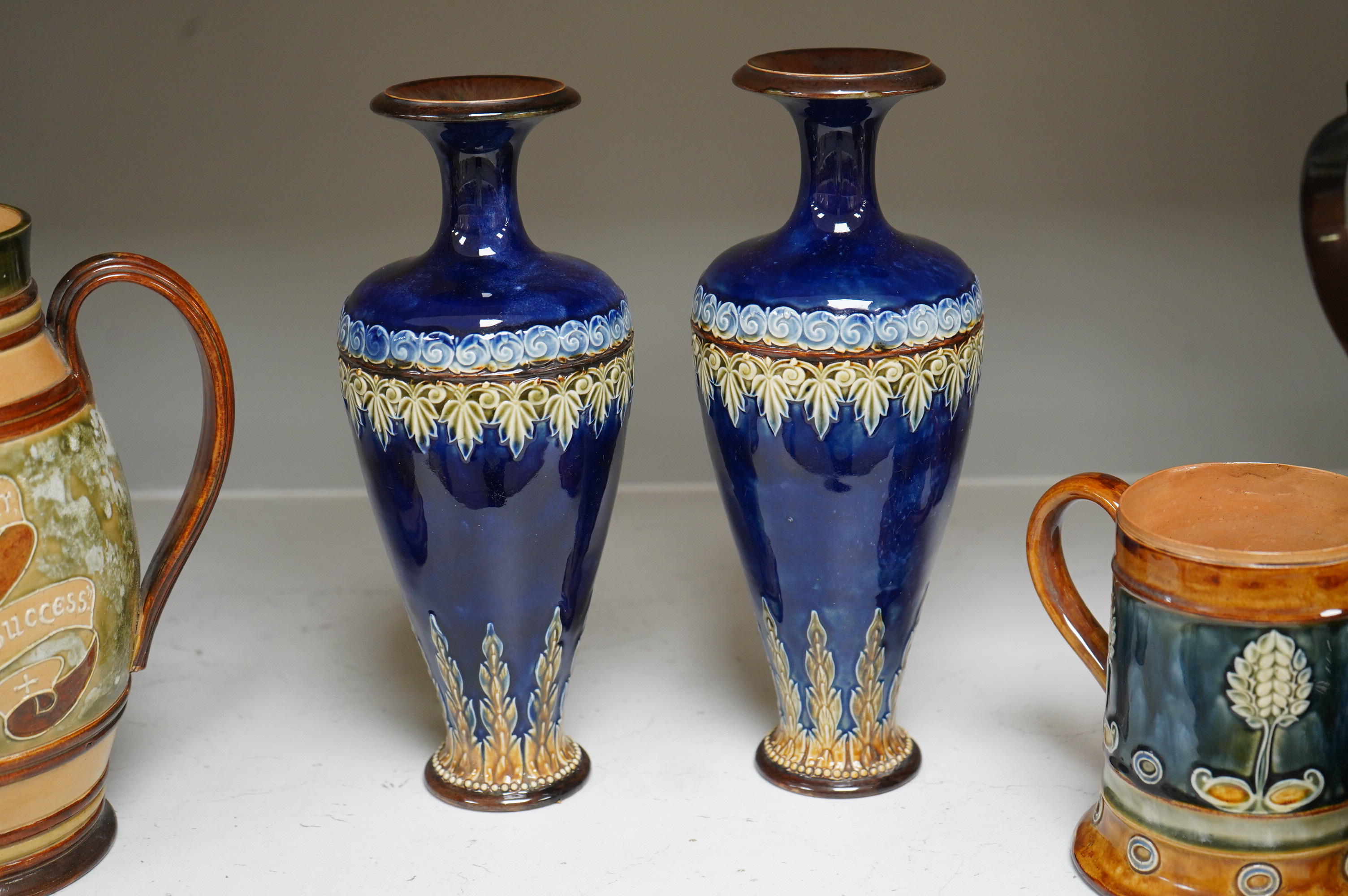 A Doulton Lambeth stoneware commemorative pitcher of William Ewart Gladstone 23cm high, together with a pair of vases two handled vase and a mug, (5).
